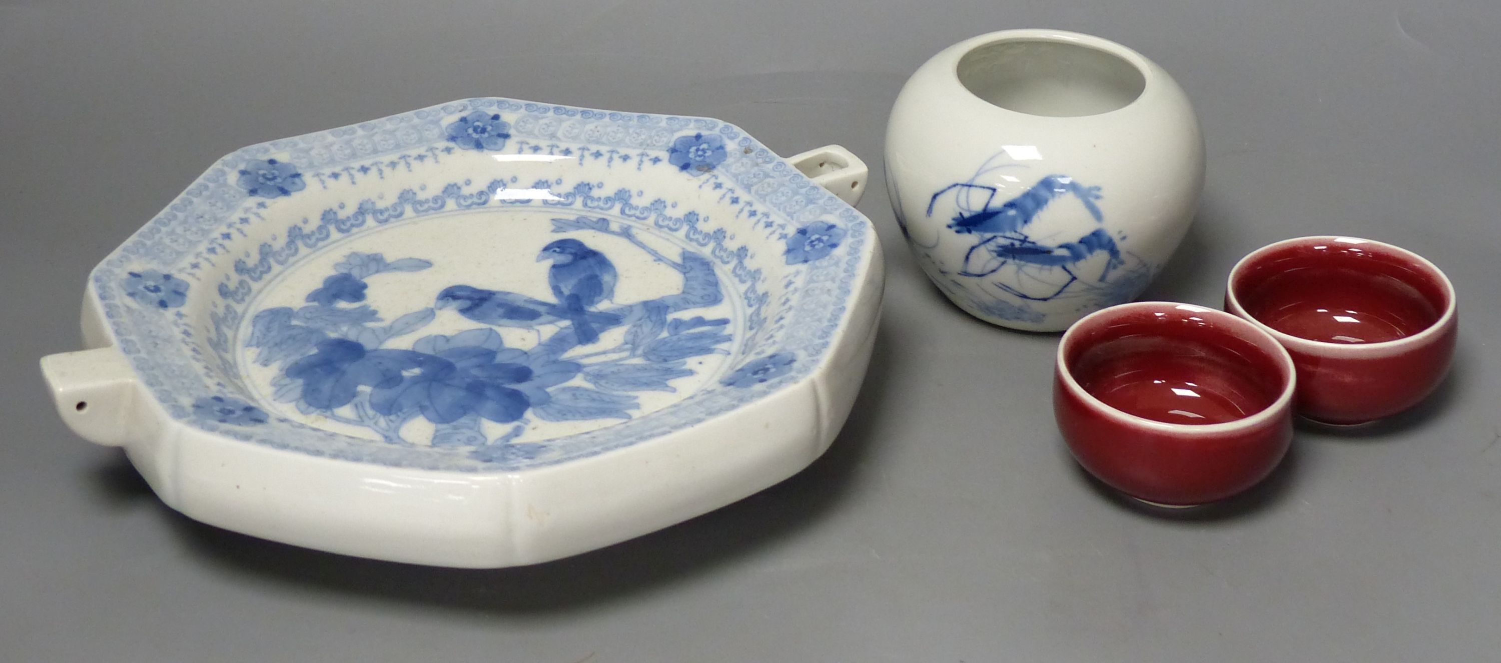 A Chinese blue and white water pot and two sang de boeuf cups and a plate warmer